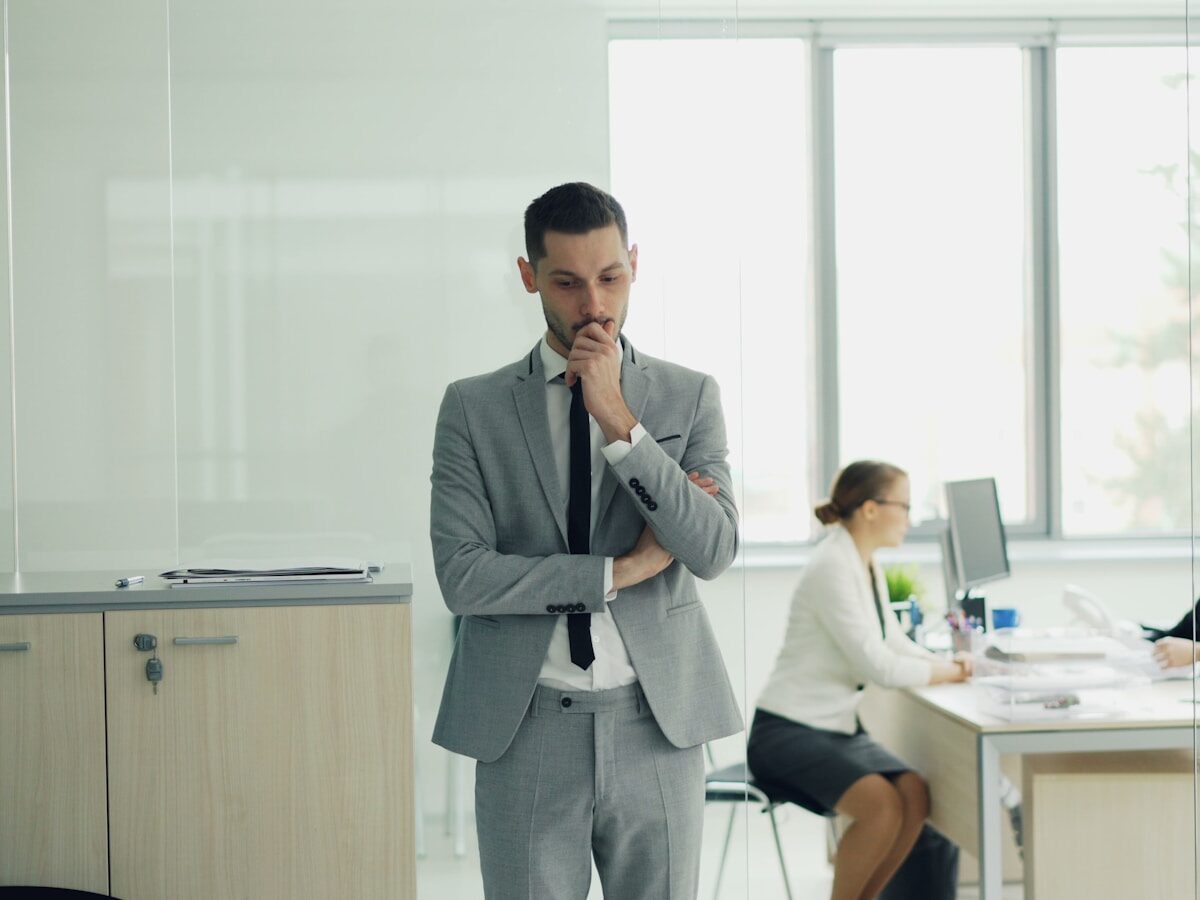 Man in suit thinking in modern office environment